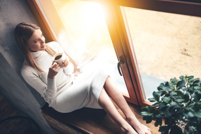Frau mit Tee im langen Pullover