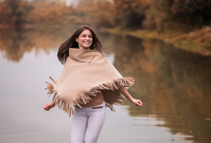 Junge Frau trägt im Herbst eine Pelerine
