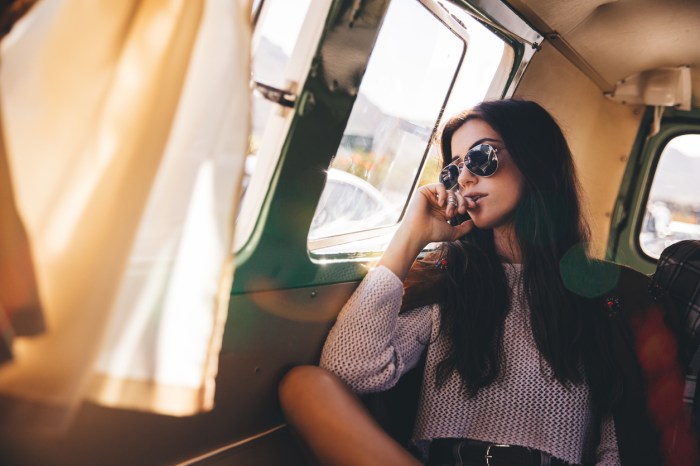 Hipster young woman looking out of a van window