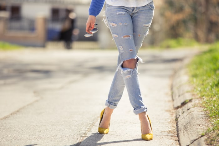 Woman legs in high heel yellow shoes on the road