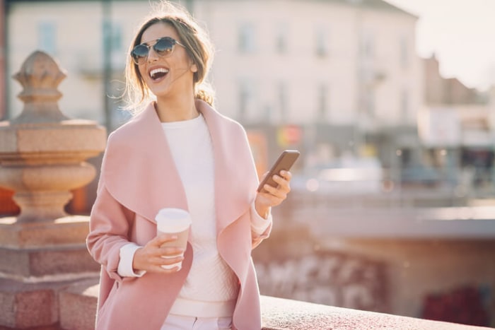 Piękna kobieta spaceruje i robi zakupy przez aplikację mobilną